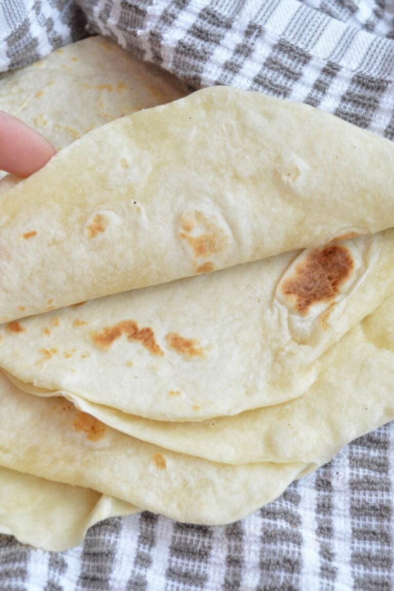 Hand folding over tortillas