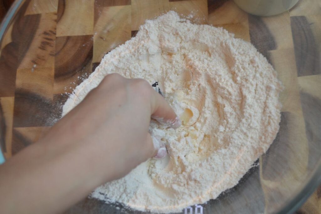 Hand mixing lard into flour