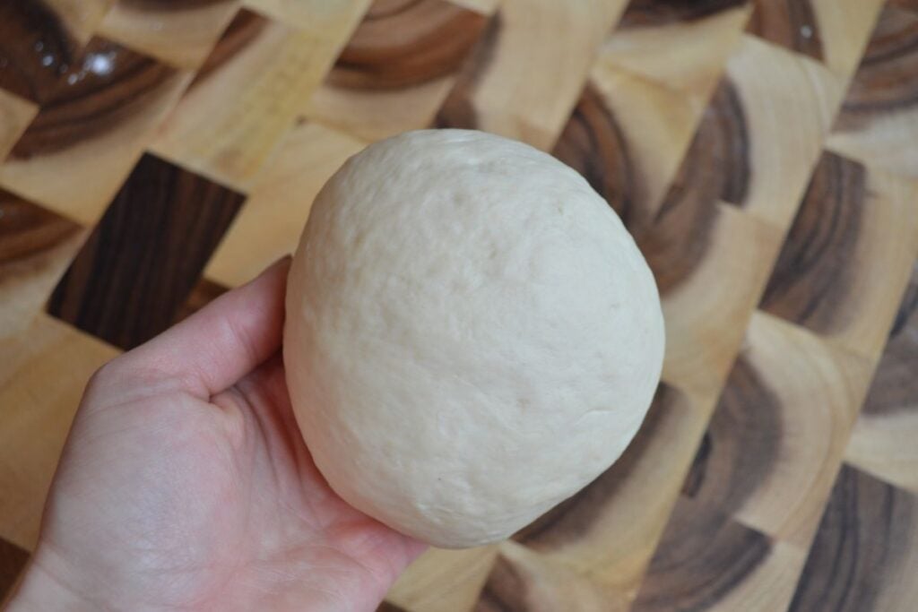 hand holding sourdough ball in hand