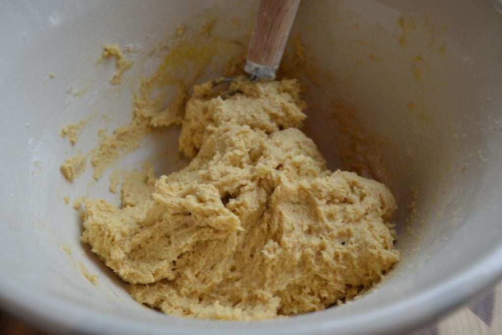 Mixed Sourdough Animal Cracker Cookie Dough in bowl with whisk