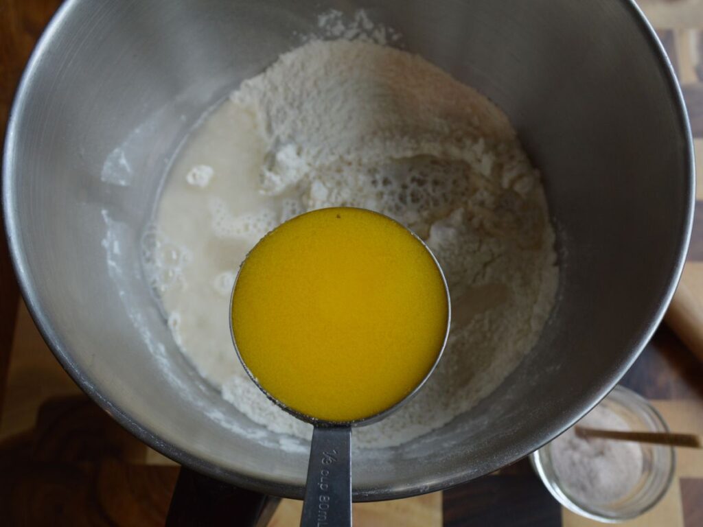 Ghee being held about ingredients in a bowl