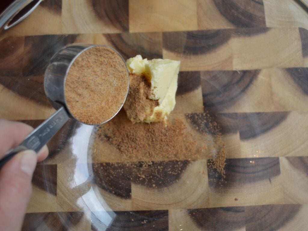 Brown sugar being poured into butter